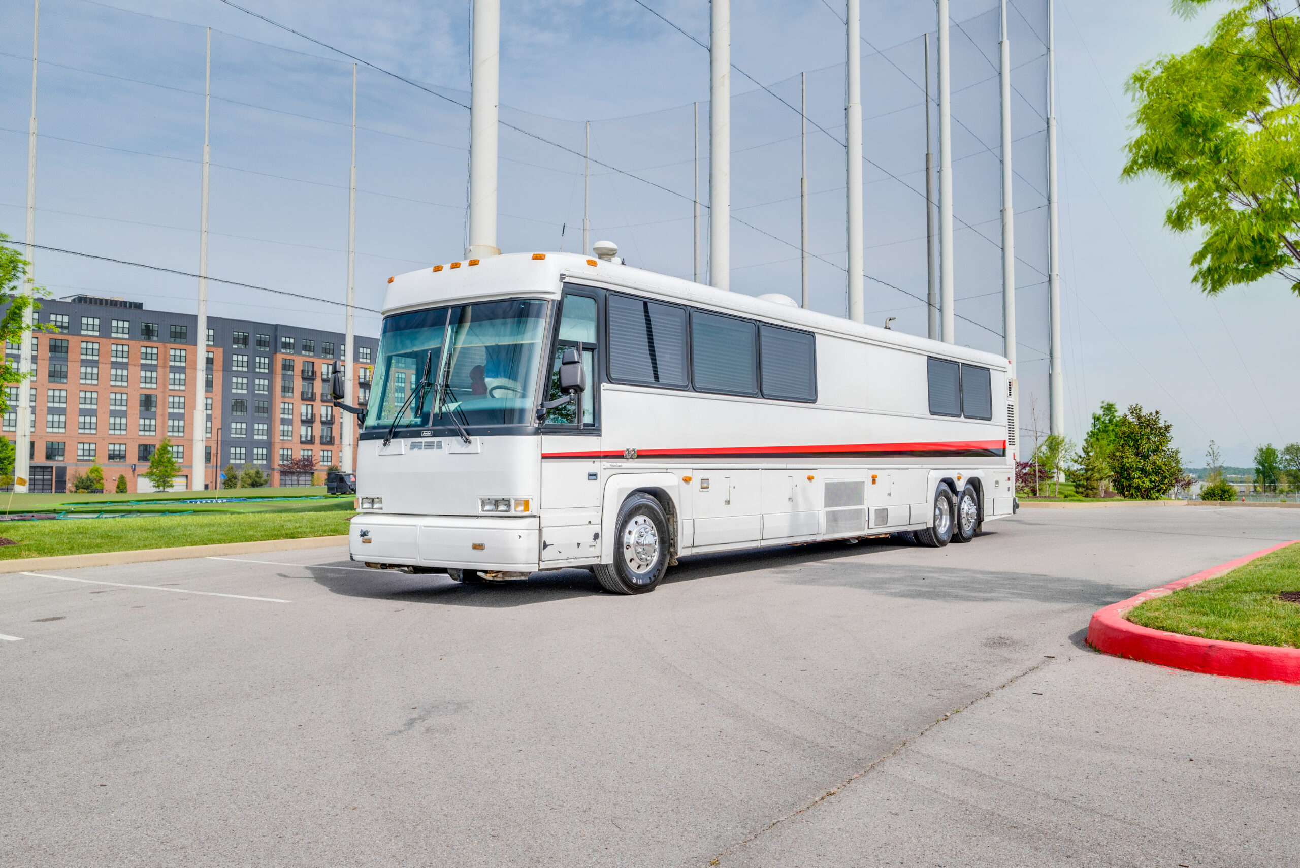 Exterior view of a white executive MCI Coach Conversion for sale.