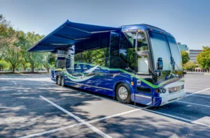 Prevost H3-45 bus with electric awning deployed—side profile in outdoor setting