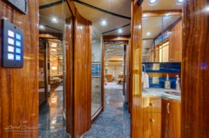 Polished wood hallway in Prevost conversion showing marble flooring and slide-out cabinetry