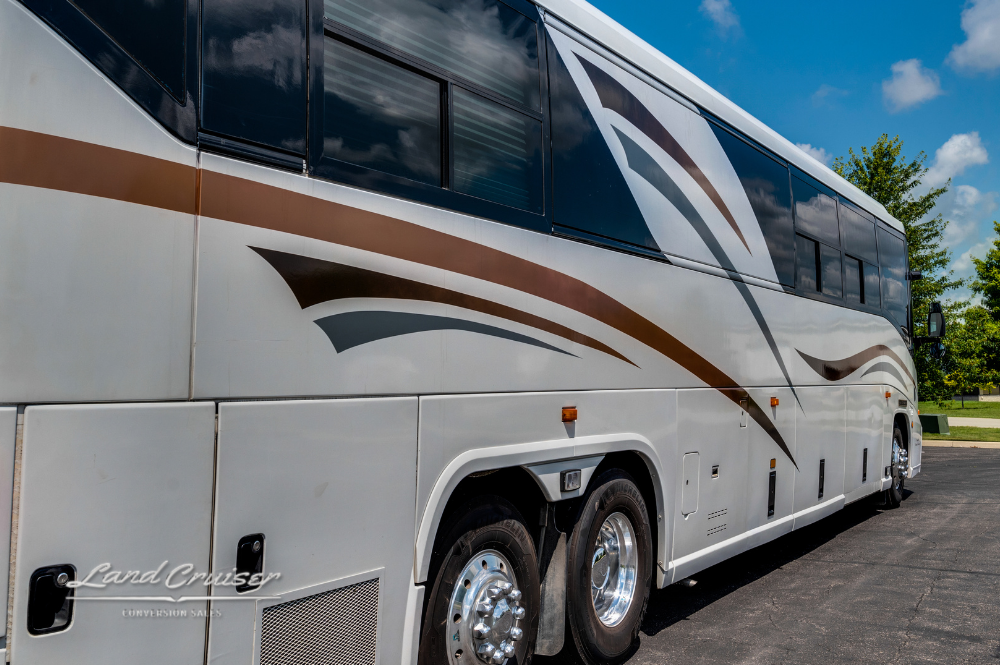Close-up of rear wheels and side paneling on MCI motorhome