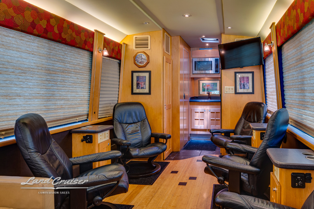 Front-to-back salon perspective with leather seating, wood cabinets, and framed wall art